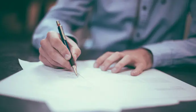 man writing on paper